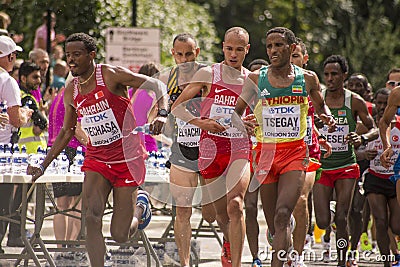 6 Aug `17 - London World Athletics Championships marathon: Bahrainian DECHASA passes water bottle to Ethiopian TSEGAY Editorial Stock Photo
