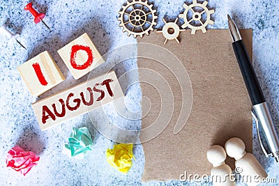 August 10 - Daily colorful Calendar with Block Notes and Pencil on wood table background. Stock Photo