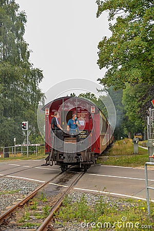 Couple men and woman at Harz steam train during winter in snow landscape, historic steam train in the winter national park Harz Editorial Stock Photo