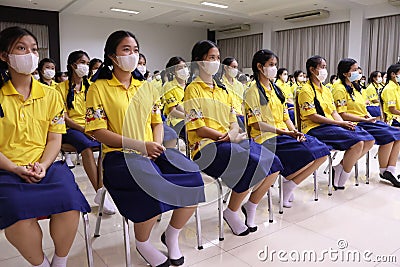 August 1, 2023, Nakhon Sawan, Thailand. Young student girls wearing face masks sit in the conference room in the morning. Editorial Stock Photo