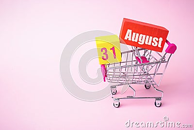 August 31st . Day 31 of month, Calendar date. Close up toy metal shopping cart with red and yellow box inside with Calendar date Stock Photo