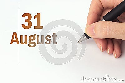 August 31st . Day 31 of month, Calendar date. The hand holds a black pen and writes the calendar date. Summer month, day of the Stock Photo