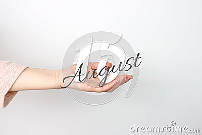 August 15th. Day 15 of month, Calendar date. Calendar Date floating over female hand on grey background. Summer month, day of the Stock Photo