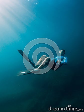 August 07, 2021. Varna, Bulgaria. Men free diver with fins in blue sea and sun rays. Freediving underwater in transparent water Editorial Stock Photo