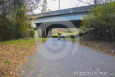 Augusta Canal Trail person on a bike riding away Editorial Stock Photo
