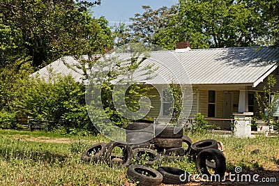 Discarded pile of car tires in a lot by a house Editorial Stock Photo