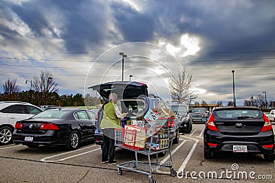 Senior putting groceries in her car wearing a face mask Editorial Stock Photo