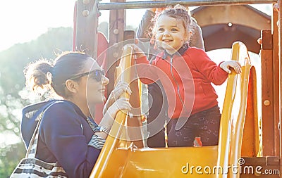 Aunt and nephew play on the slide at the park Stock Photo