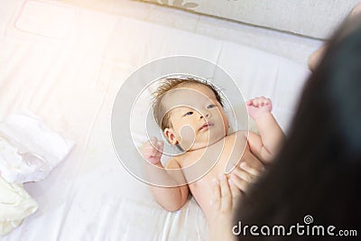 Aunty apply oil cream for baby girl Stock Photo