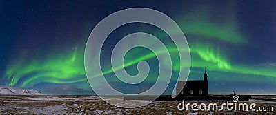 Aurora borealis above the church in Iceland. Green northern lights. Starry sky with polar lights. Stock Photo