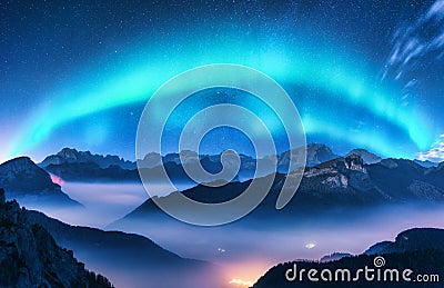 Aurora borealis above mountains in fog at night Stock Photo