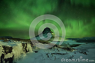 Aurora Borealis the Northern Light at Kirkjufell Iceland. scenic view of waterfall Kirkjufellsfoss aurora polaris in background. Stock Photo