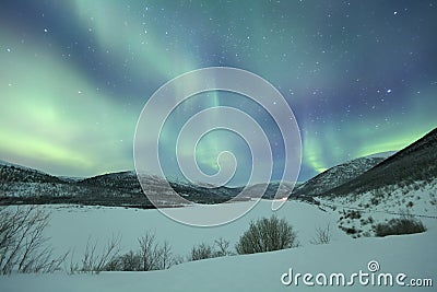 Aurora borealis over snowy winter landscape, Finnish Lapland Stock Photo