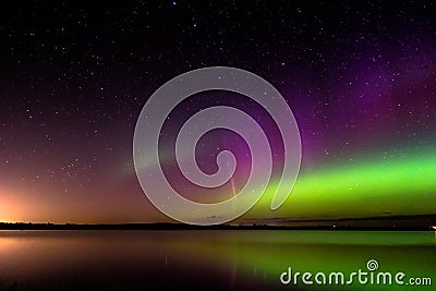 Aurora borealis with proton arc reflected over a lake Stock Photo