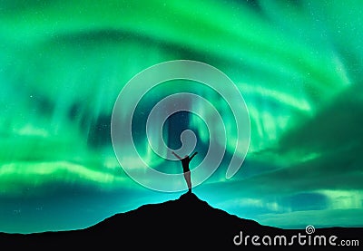 Aurora borealis and silhouette of a woman with raised up arms Stock Photo