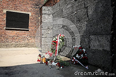 Flowers and candles by the Wall of Death, Auschwitz Editorial Stock Photo