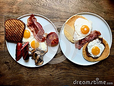 Aussie / Australian Breakfast with Brioche Toast, Fried Eggs, Crispy Bacon Sausage, Salty Pancakes and Mushrooms Stock Photo