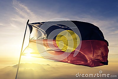 Australian Aboriginal flag textile cloth fabric waving on the top sunrise mist fog Stock Photo
