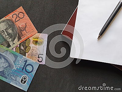 Australian banknotes, black pen and books Stock Photo