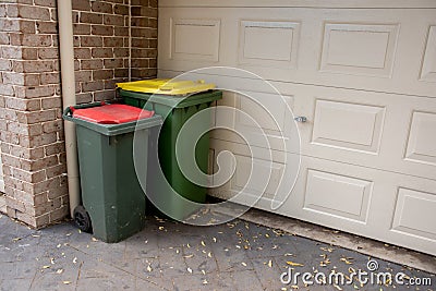 Australian garbage wheelie bins with red and yellow lids for general and recycling household waste near the resedential building Stock Photo