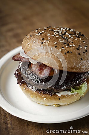 Organic beef burger with bacon on wood table Stock Photo