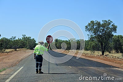 Australian road worker holding a stop sign on an outback road Editorial Stock Photo