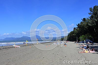 Australian tourists sunbathing on Port Douglas main. beach in the tropical far north Queensland Australia Editorial Stock Photo