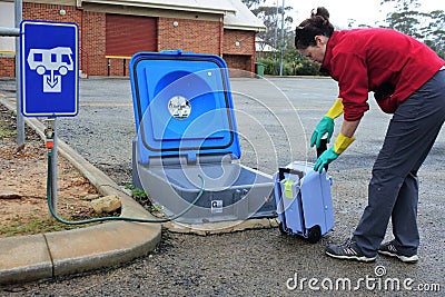 Australian woman emptying a caravan tank toilet cassette in a dumping point Stock Photo