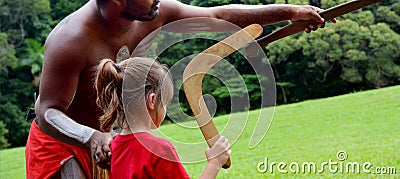 Australians aboriginals man teaches a young girl how to throw a Stock Photo