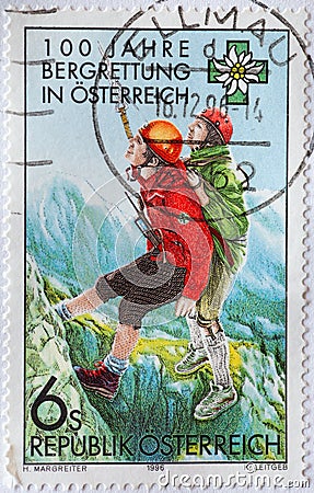 AUSTRIA - CIRCA 1996 : a postage stamp printed in the Austria showing a rescuer from the mountain rescue service bringing an injur Editorial Stock Photo