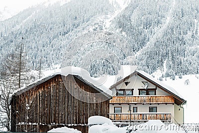 Austrian alpine village scenic landscape with small chalet and wooden barn ,pine forest trees and snow covered mountains on Stock Photo