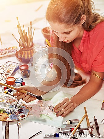 Authentic artist children girl paints on floor. Sun flare. Stock Photo