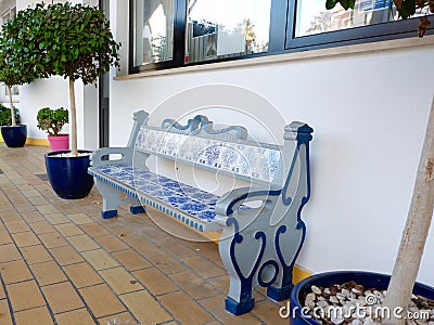 Authentic bench decorated with ceramic tiles of blue and white colour outside in the shade of the yard in Carvoeiro, Portugal Stock Photo