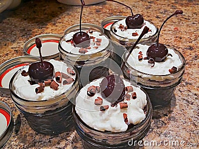 Authentic Black Forest Cake Baked in Mason Jars with Kirsh, Whipped Cream, and a Cherry Stock Photo