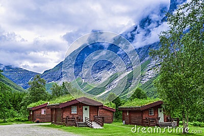 Authentic cabins with green grass on the roof at the foot of the popular Troll Stair or Trollstigen serpentine road Stock Photo