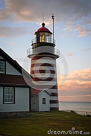 Authentic Fresnel Lens Shines Brightly During Sunset at West Quoddy Head Lighthouse in Maine Stock Photo