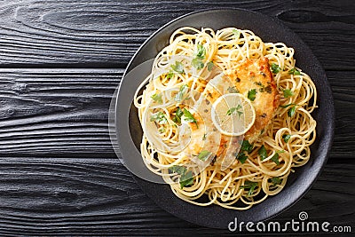 Authentic fried breaded chicken Francaise with spaghetti in lemon wine gravy close-up on a plate. Horizontal top view Stock Photo