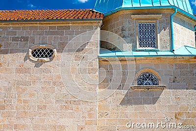 Authentic house with a stone wall and a beautiful green door and with a beautiful stone bench at the entrance Stock Photo