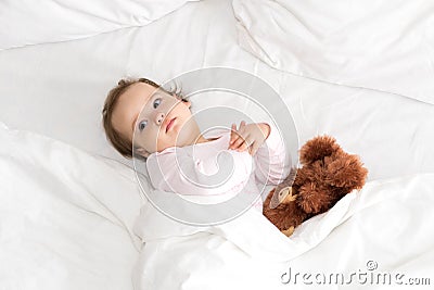 Authentic portrait cute caucasian little infant chubby baby girl or boy in pink sleepy upon waking with teddy bear Stock Photo