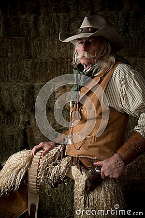 Authentic western cowboy with leather vest, cowboy hat and scarf portrait Stock Photo