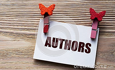 AUTHORS - word on a white sheet with beautiful clothespins on a wooden background Stock Photo