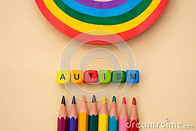 Autism word wooden colorful cubes and rainbow. Mental health, social suport. Special education concept Stock Photo