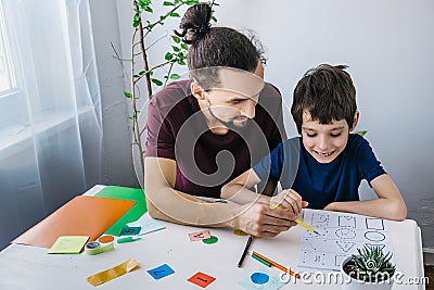 Autistic boy during therapy at home with his father with learning and having fun together. Autism awareness concept Stock Photo