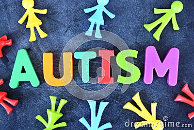 Autistic child concept with colorful plastic letter spelling autism on dark background Stock Photo