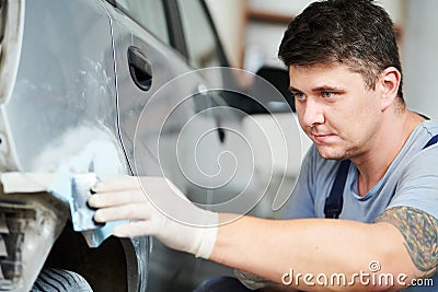 Auto repairman plastering autobody bonnet Stock Photo
