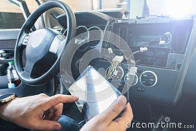 Auto in Car Service, process of installing radio sound system. Auto electric hands on dashboard fixing problem close-up Stock Photo