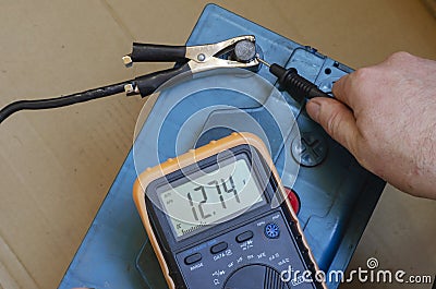 Auto electrician checks the charge quality of an auto battery Stock Photo