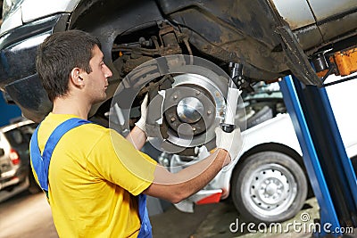 Auto mechanic at car suspension repair work Stock Photo