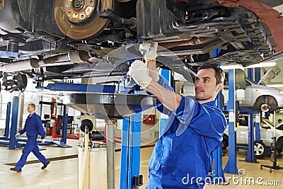 Auto mechanic at car suspension repair work Stock Photo