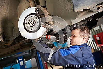 Auto mechanic at car suspension repair work Stock Photo